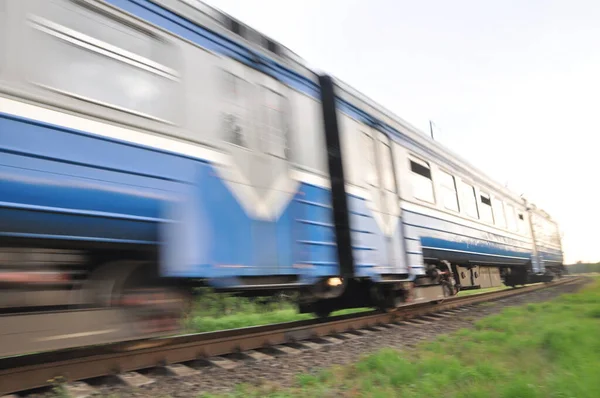 A high-speed diesel train moves quickly by rail. Blur, out of focus