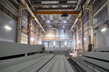 Endüstriyel bina içi. Ön planda bitmiş metal yapılar var.