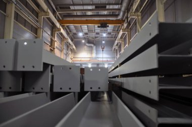 Endüstriyel bina içi. Ön planda bitmiş metal yapılar var.