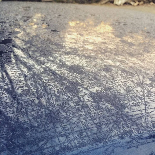 The top of a car on an icy, cold morning.