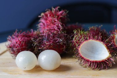 bütün ve ahşap masa üzerinde yatan olanlar kırpma ile tay egzotik meyve rambutan bir demet