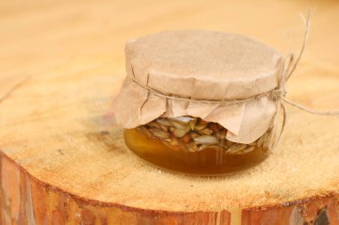 Ahşap masa üzerinde bal ayçiçeği tohumu ile Kavanoz. Lezzetli doğu tatlısı