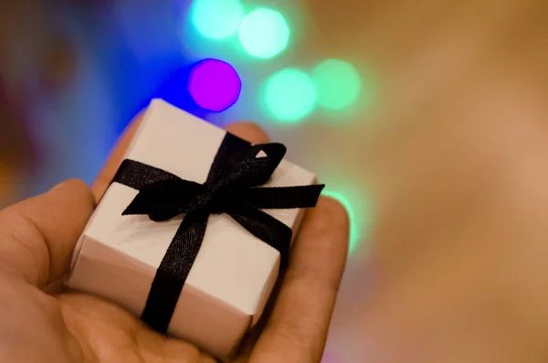 Noel hediye veya yandan gece mavi bokeh arka plan üzerinde siyah kurdele ile yeni yıl çok az. Küçük el yapımı hediyelik konsepti. — Stok fotoğraf