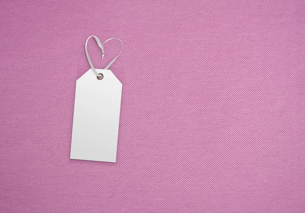 Clothes label tag on cloth background. Branding template mockup