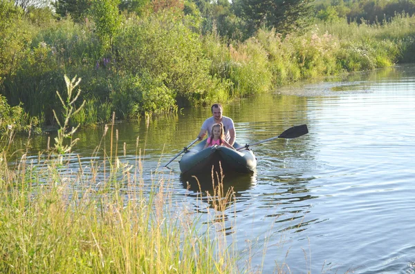 Beautiful sunlight river landscape. Shady pond with summer grass, meadow flowers, algae. Water reflections. Summer day.