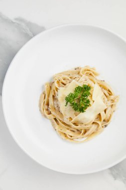 Yer mantarı kremalı makarna, beyaz mermer arka planda beyaz tabakta Tagliatelle kremalı beyaz şarap sosu.
