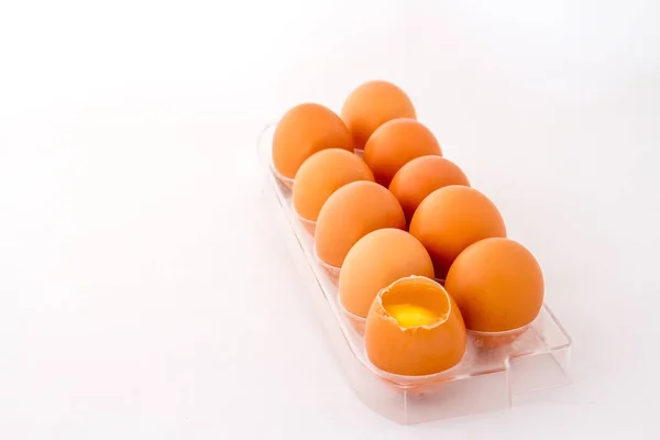 Chicken eggs one broken in a tray isolated against a white background image with copy space in landscape format