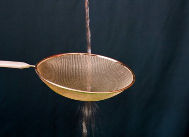 Manzara biçiminde kopya alanı ile açık bir arka plan karşı izole bir elek ile dökülen su akışı