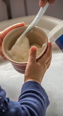 Küçük bir beyaz çocuk portre biçiminde gıda resim bir kase tutarak eller