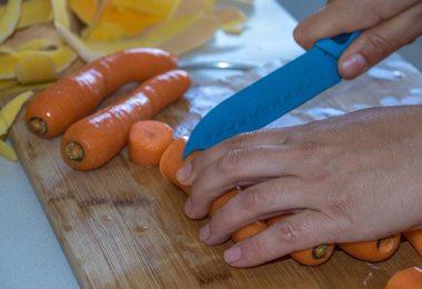 El kopya alanı manzara biçiminde bir ahşap tahta görüntüsüyle üzerinde keskin bir bıçak kullanarak sebze kesme yakın çekim