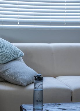 Bir cam şişe su kopya alanı portre biçiminde bir modern lounge görüntü serin bir köşesinde bir yan masada
