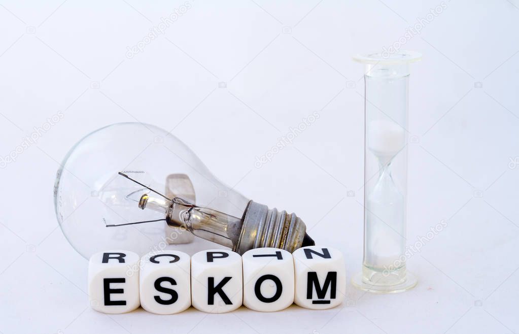 A fused electric light globe, a hourglass and the name eskom in black text on a white background image with copy space in landscape format
