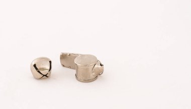 Düdükler ve gümüş bir çan, beyaz arkaplan görüntüsü üzerinde izole edilmiş, kopya alanı olan manzara biçimi