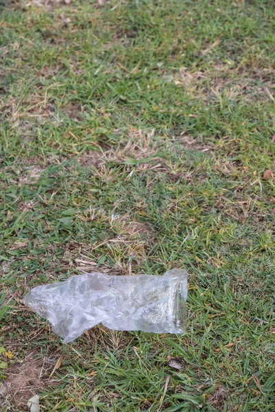 An isolated single-use plastic bag lies abandoned in nature image with copy space
