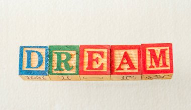 Görsel olarak beyaz bir arka plan üzerinde görüntülenen rüya terimi, yatay formatta kopya alanı ile renkli ahşap bloklar görüntü