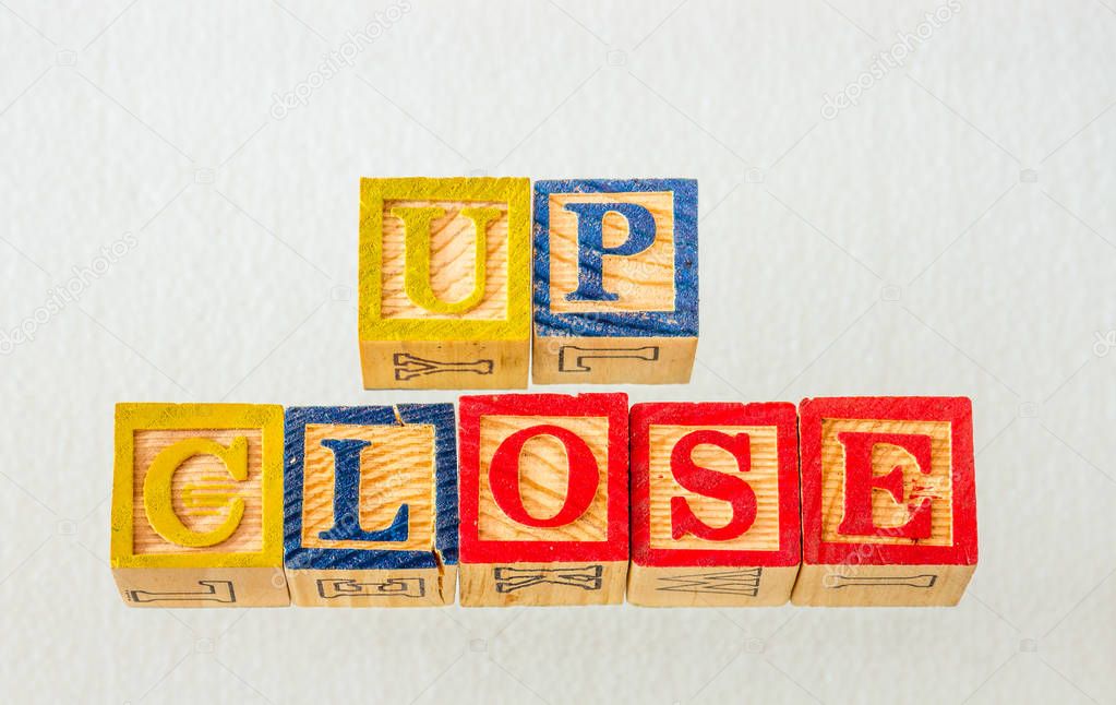 The term up close visually displayed using colorful wooden blocks on a clear background image with copy space in landscape format