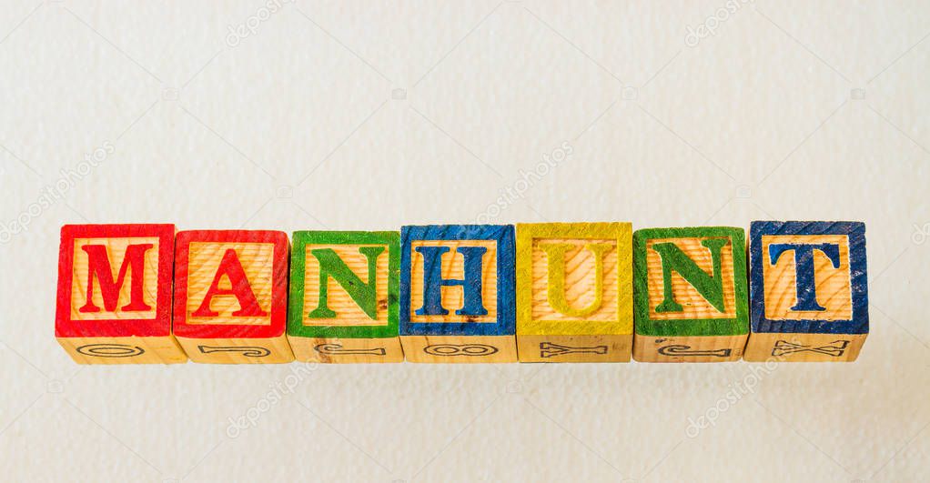 The term manhunt visually displayed on a clear background using colorful wooden blocks image in landscape format with copy space