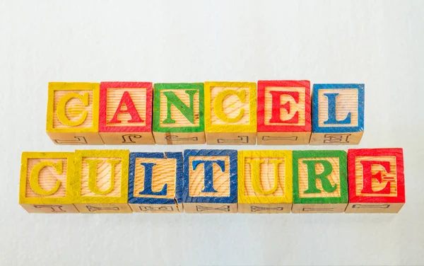The term cancel culture visually displayed on a clear background using colorful wooden toy blocks image in landscape format