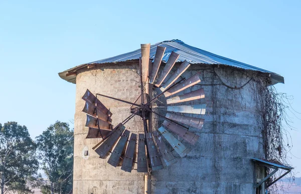 風景形式で古い灰色の石塔の画像に取り付けられた壊れたヴィンテージ風車 — ストック写真
