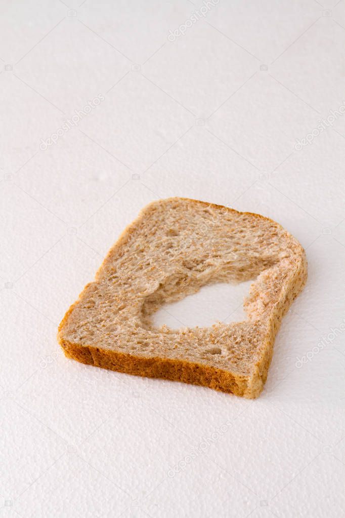 A slice of bread with a chunk missing in the middle isolated on a white background image with copy space