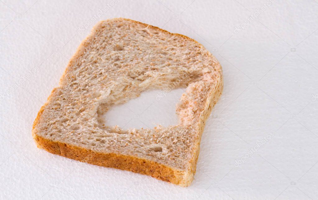 A slice of bread with a chunk missing in the middle isolated on a white background image with copy space