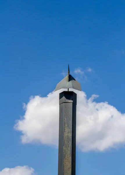 垂直形式でコピースペースを持つ白い雲の画像と青い空に対して隔離された気象ベーンと黒の金属煙突 — ストック写真