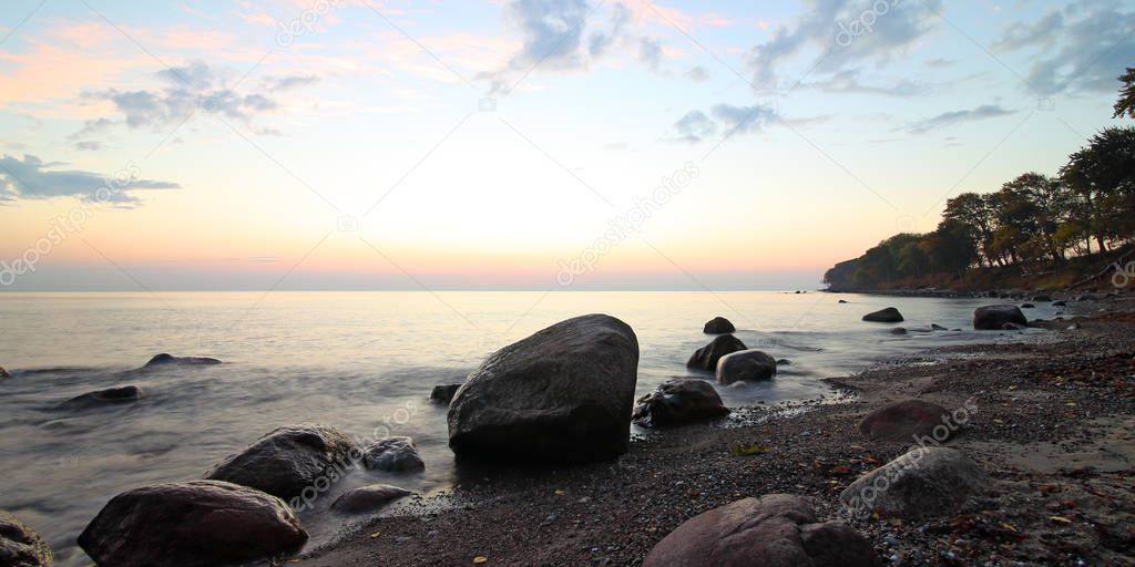 Coast with small and big rocks at sunset