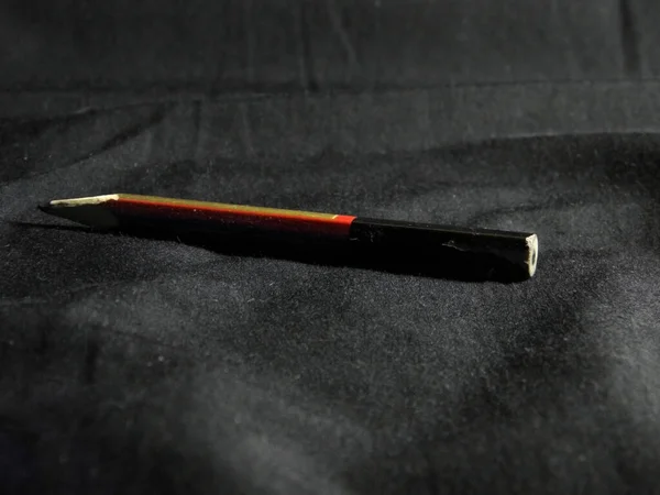 A hard pencil for fine art lies on a dark fabric