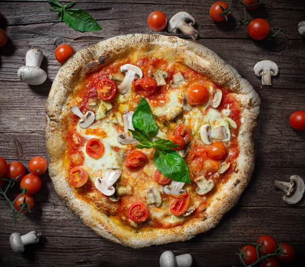 Pizza con champiñones frescos tomates cherry y mozzarella en mesa de madera rústica — Foto de Stock