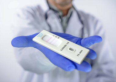 Covid-19 test kit for the detection of IgM / IgG antibodies and immunity in 15 minutes, in hand using a disposable glove. clipart