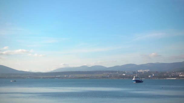 Barcos flutuar contra bela paisagem, montanha e cidade à distância . — Vídeo de Stock