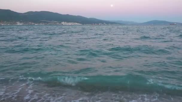 Vacker solnedgång över stormigt hav. Hamnstad i fjärran. — Stockvideo