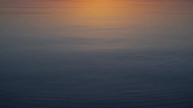 Taş sakin su üzerinde atlama etrafında güzel gün batımı.