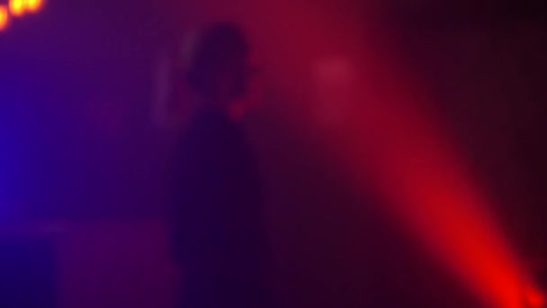 Vacker kvinna dans i färgglada ljusstrålar i trendig nattklubb. — Stockvideo