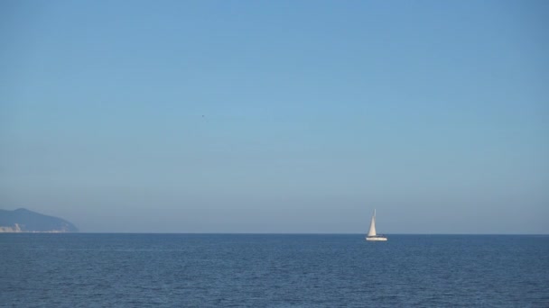 Beau voilier flotte sur des vagues de mer calme .