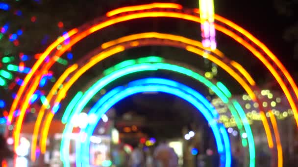 Eintritt in Vergnügungspark bei Nacht, buntes Licht moderner Attraktionen als Hintergrund. — Stockvideo