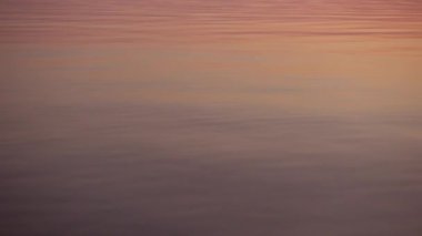 Taş, güzel günbatımı atlama yansıtan su yüzeyine.