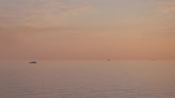 Yacht and big ocean cargo ship in sea at beautiful sunset. — Stock Video