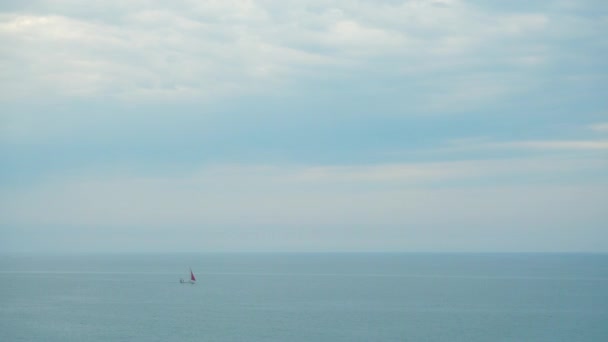 One sailboat with red sail in the sea. — Stock Video