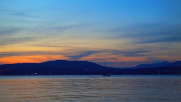 Hermosa puesta de sol sobre el agua y el barco flota en la distancia . — Vídeos de Stock