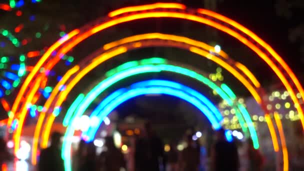 Les gens dans le parc d'attractions la nuit, lumière colorée des attractions modernes comme arrière-plan . — Video