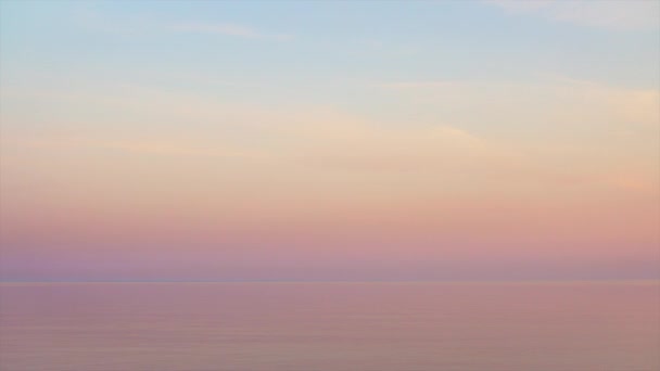 Величний захід сонця в пастельних тонах над спокійною водою. Безшовне відео на петлі . — стокове відео