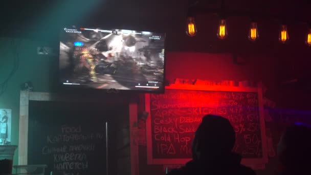 Personer spelar dataspel. Nattliv i trendiga baren. — Stockvideo