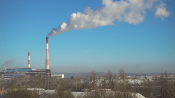 Трубы с дымом тепловой электростанции зимой в прекрасный солнечный день . — стоковое видео