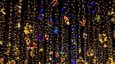 Güzel renkli tatil süslemeleri, Noel oyuncakları, gece gökyüzünde rüzgarda sallanan çelenkler..