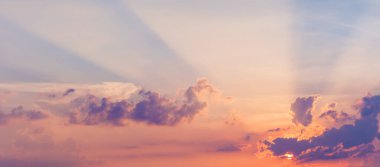 Güneş ışınlı güzel bir gökyüzü. Pastel tonlarda görkemli renkli bulutlar.