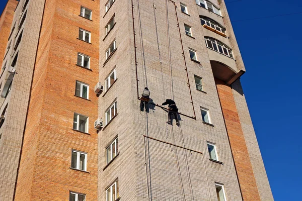 Endüstriyel tırmanma. İşçiler bir bina üzerinde reklam asmak. Yükseklikte çalışma