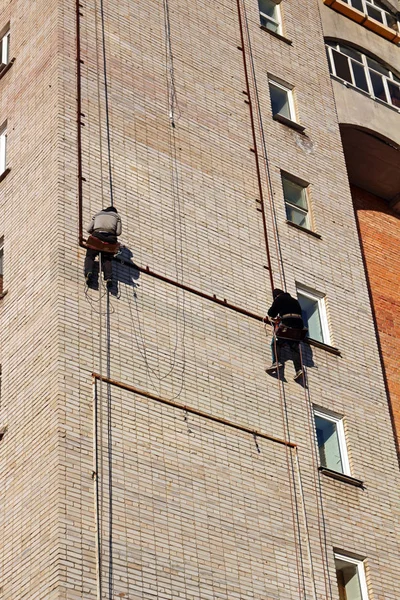 Endüstriyel tırmanma. İşçiler bir bina üzerinde reklam asmak. Yükseklikte çalışma