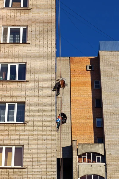 Endüstriyel tırmanma. İşçiler bir bina üzerinde reklam asmak. Yükseklikte çalışma