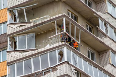 OBNINSK, Rusya - 22 Nisan 2018: Hasar sonucu olarak bir güçlü kasırga rüzgar 20 katlı ev loggias. İşçilerin zarar görmüş yapıları ortadan kaldırmak.